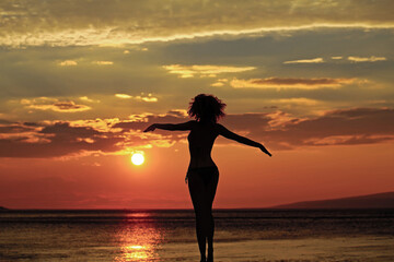 Woman silhouette on beach near sea or ocean water in evening or twilight sunset summer day on...
