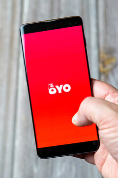 04-13-2021 Portsmouth, Hampshire, UK A Mobile phone or Cell phone being held in a hand showing the oyo app on screen
