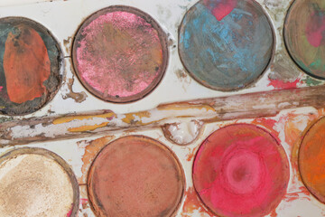 Messy watercolor paints palette, close up.
