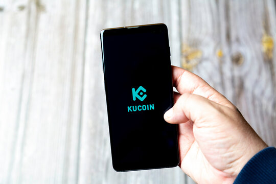 04-13-2021 Portsmouth, Hampshire, UK A Mobile phone or Cell phone being held in a hand showing the kucoin app on screen