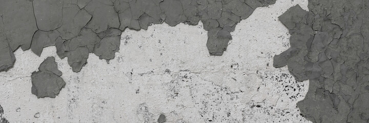 Peeling paint on the wall. Panorama of a concrete wall with old cracked flaking paint. Weathered rough painted surface with patterns of cracks and peeling. Wide panoramic texture for design background