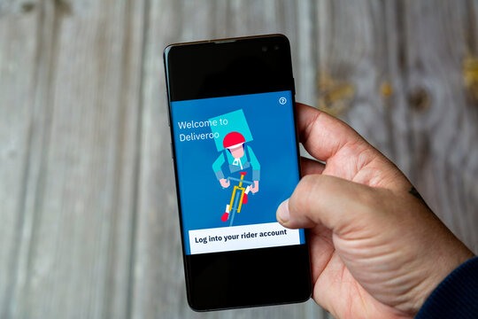 04-13-2021 Portsmouth, Hampshire, UK A Mobile phone or Cell phone being held in a hand showing the deliveroo rider app on screen