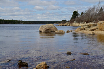 Stone and forest lake shore in the Nova Scotia, Canada.