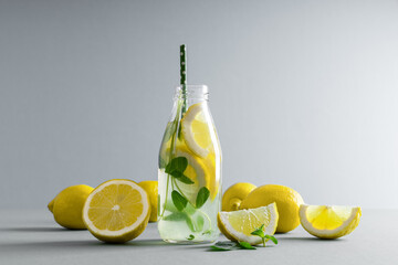 Detox water with mint, lemon on grey background.  Citrus lemonade. Summer fruit infused water....