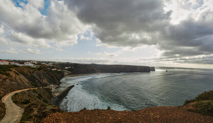 Panoramic view from the top of arrifana beach in aljezur Portugal, fishing port, beach and cliffs of arrifana and the needle stone called Pedra da Agulha in Portuguese.