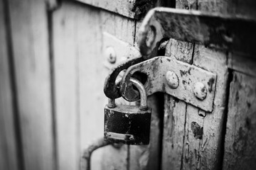 A rusty old lock on a wooden door.