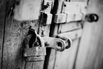 A rusty old lock on a wooden door.