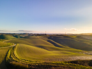 Scenic countryside landscape at sunset. Rolling hills in Tuscany. Drone view, aerial shot.