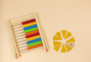 Multicolored wooden abacus on a beige background. Educational toys for kindergarten, preschool, or daycare. Back to school. Close up	
