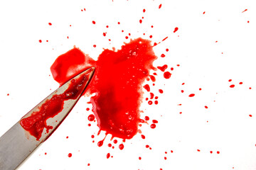 A sharp knife with drops of blood spread on a white background.