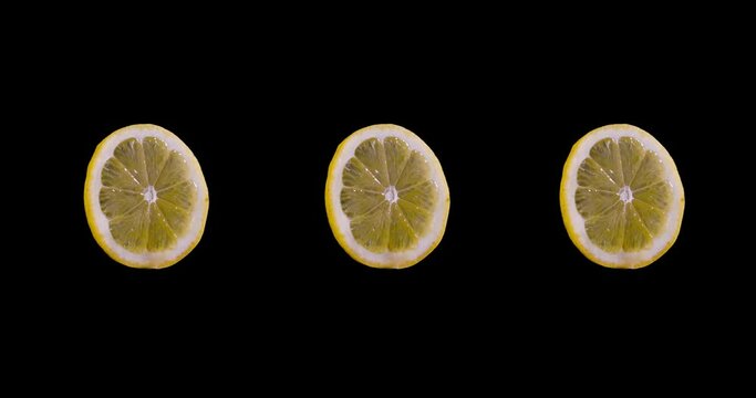 3 citron slices spinning in circles isolated on a black background