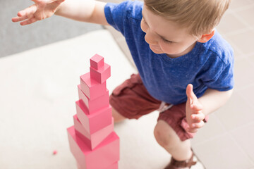 Little boy with Montessori pink tower