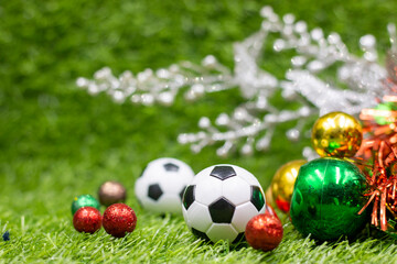 Soccer ball with Christmas Decoration on green grass for Christmas Holiday 