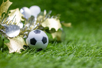 Fototapeta premium Soccer ball with Christmas Decoration on green grass for Christmas Holiday 