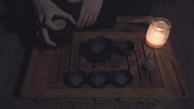 Tea master pours green tea in a circle into a mug saturating the drink with oxygen. The concept of Chinese and Japanese tea ceremonies, hobbies and lifestyle