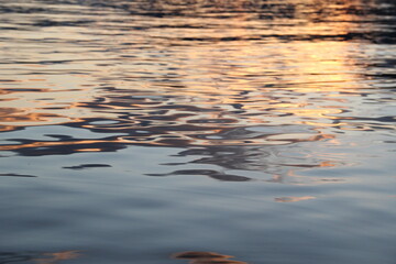 Golden yellow sunset reflection on the water surface of the lake