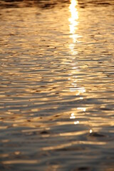 Golden yellow sunset reflection on the water surface of the lake