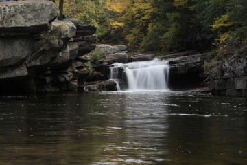 Fototapeta premium Colorful Vermont autumn foliage waterfall down the river in the forest