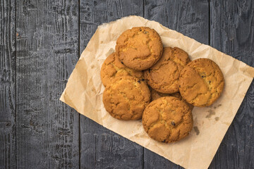 Top view of a cookie on a piece of wrapping paper on a wooden table.