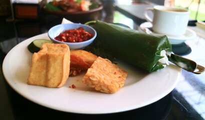 Nasi timbel.  Indonesian hot dish, consisting of steamed rice wrapped inside a banana leaf. It is a traditional Sundanese cuisine from West Java.