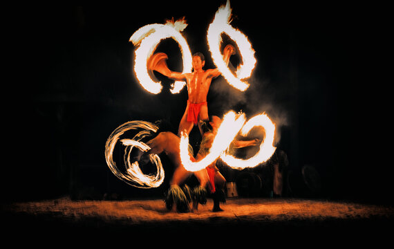 Luau hawaiian fire dancers motion blur tourist attraction in Hawaii or French Polynesia, traditional polynesian dance with men dancer.