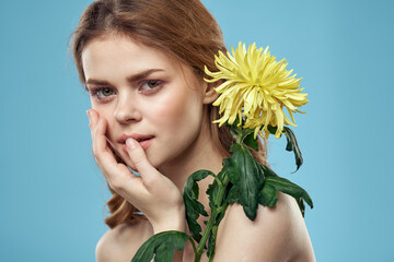 Emotional woman with flowers spring model naked shoulders clear skin