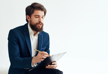 business man in a blue jacket and in a white shirt with documents in a folder on a light background