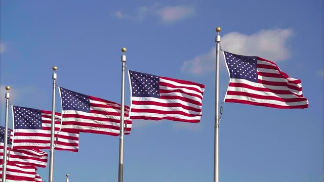 Flags of the United States in Washington DC waving over blue sky