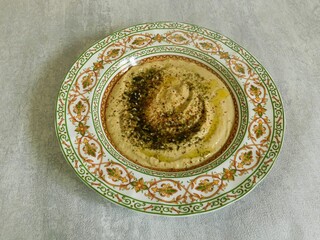 homemade hummus with herbs and olive oil in a traditional oriental dish. vegetarian, healthy food.