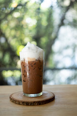 Glass of iced mocha coffee with milk foam, espresso mixed with chocolate or cocoa topped with milk foam.
