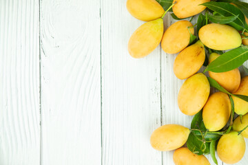Marian plum fruits or mayongchid with green leaf on white table