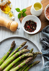 Bunch of raw asparagus stems with different spices