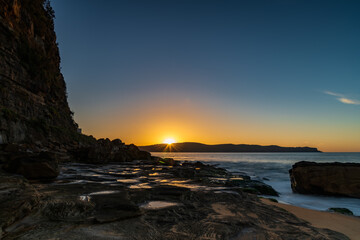 Fototapeta na wymiar Sunrise seascape with headland and sunburst