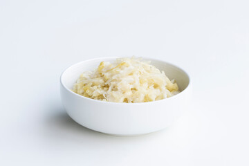 Fresh homemade sauerkraut in a bowl isolated on a white background. Sauerkraut is finely cut raw cabbage that has been fermented by various lactic acid bacteria.