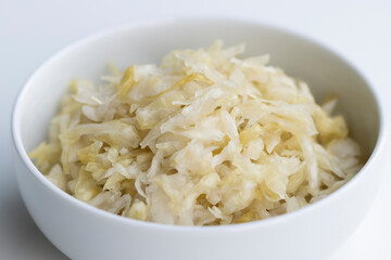 Close up of fresh homemade sauerkraut in a bowl isolated on a white background. Selective focus.