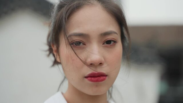 4k slow motion of one beautiful sad asian woman looking at camera tears in the eye unhappy woman portrait hair on the face