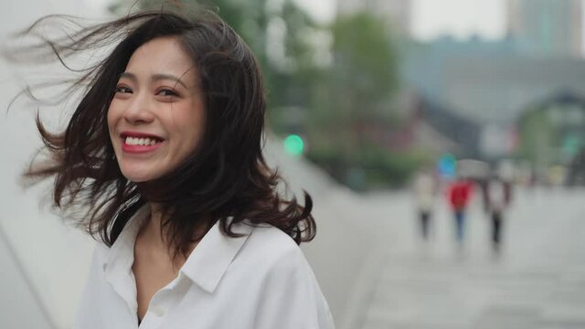 4k slow motion back view of lovely asian girl walking in the urban street turn back looking at camera smile lovely woman girlfriend traveling in the city portrait