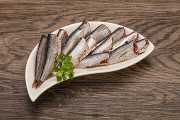 Anchovies in the bowl served basil leaves