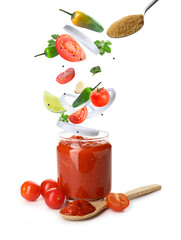 Jar of tasty tomato sauce with falling ingredients on white background