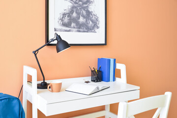 Comfortable workplace near color wall in room