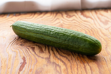 green cucumber on the wooden surface of the table