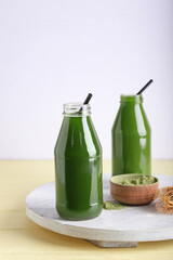 Tray with bottles of matcha tea, powder and chasen on table