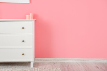 Chest of drawers near color wall in room