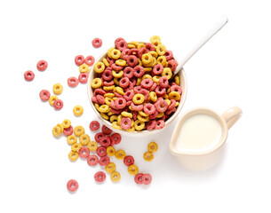 Bowl with tasty cereals and jug of milk on white background