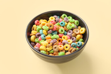 Bowl with cereal rings on color background