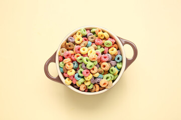 Pot with tasty cereal rings on color background