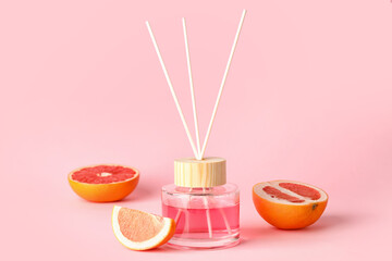 Reed diffuser with grapefruits on color background