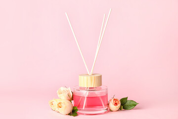 Obraz na płótnie Canvas Reed diffuser with roses on color background