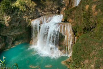 Fototapeta na wymiar Turquoise blue waterfall in the tropical jungle