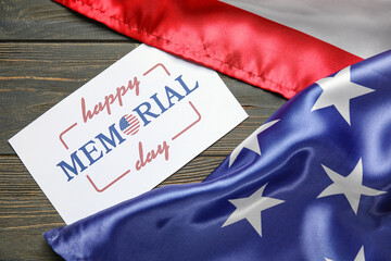 Paper sheet with text MEMORIAL DAY and USA flag on dark wooden background
